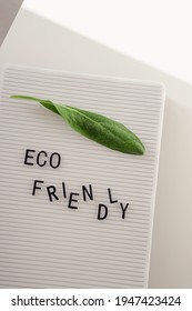 Zero Waste Concept, Pros And Cons. Black Letters On A Peg Board With Message Text Eco Friendly And A Fresh Green Leaf On White Background. Flat Lay.