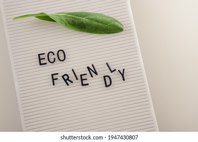 Zero Waste Concept, Pros And Cons. Black Letters On A Peg Board With Message Text Eco Friendly And A Fresh Green Leaf On White Background. Flat Lay.