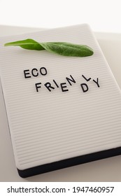 Zero Waste Concept, Pros And Cons. Black Letters On A Peg Board With Message Text Eco Friendly And A Fresh Green Leaf On White Background. Flat Lay.