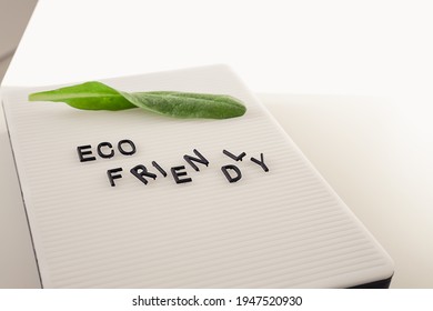 Zero Waste Concept, Pros And Cons. Black Letters On A Peg Board With Message Text Eco Friendly And A Fresh Green Leaf On White Background. Flat Lay.