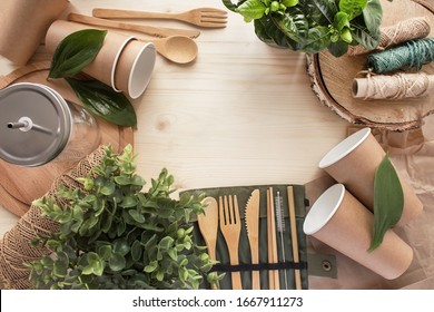 Zero waste concept. Set of bamboo appliances, reusable cups, green plants and tree. No plastic. Place for text.