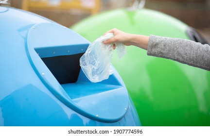 Zero Waste Concept. Unrecognizable Woman Throwing Single Use Plastic Bag Into Blue Recycle Bin Outdoors, Sorting Garbage To Different Trash Containers, Cropped Image With Selective Focus, Panorama