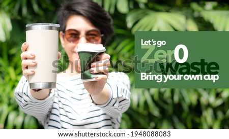 Zero waste concept, A young beautiful asian woman holding a reusable stainless steel tumbler cup with green typography design say 