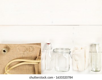 Zero Waste Or Waste Free Shopping Utensils With Burlap Bag, Glass Bottles And Bag On White Wooden Table Background Flat Lay From Above - Waste Reduction Eco Lifestyle Or Bulk Buy Grocery Concept