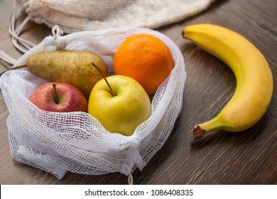 Zero Waste, Plastic Free Recycled Textile Produce Bag For Carrying Fruit (apple, Orange, Pear And A Banana) Or Vegetables, A Wooden Surface. Bags Are Made With A Sewing Machine Out Of Old Curtains.