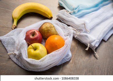 Zero Waste, Plastic Free Recycled Textile Produce Bag For Carrying Fruit (apple, Orange, Pear And A Banana) Or Vegetables, A Wooden Surface. Bags Are Made With A Sewing Machine Out Of Old Curtains.