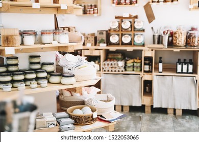 Zero waste shop interior details. Wooden shelves with different food goods and personal hygiene or cosmetics products in plastic free grocery store. Eco-friendly shopping at local small businesses