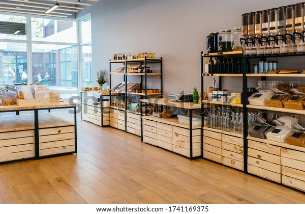 Zero waste shop interior. Wooden shelves with\
different food goods and personal hygiene or cosmetics products in\
plastic free grocery store. Eco-friendly shopping at local small\
businesses