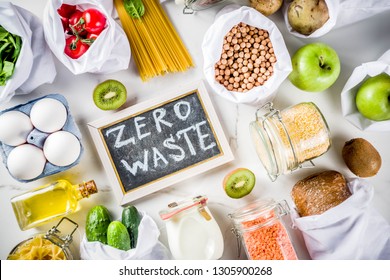 Zero waste shopping and sustanable lifestyle concept, various farm organic vegetables, grains, pasta, eggs and fruits in reusable packaging supermarket bags. copy space top view, white concrete table - Shutterstock ID 1305900268