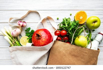 Zero waste shopping and sustanable lifestyle concept, various farm organic vegetables and fruits in reusable packaging supermarket bags. Copy space top view, wooden background - Powered by Shutterstock