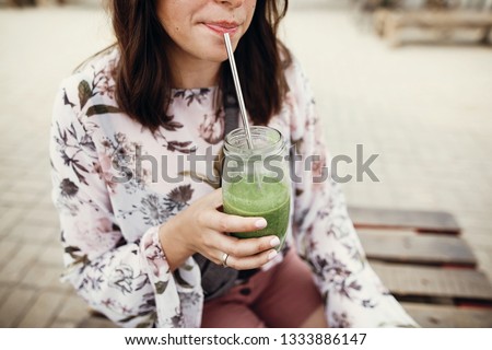 Similar – Frau mit Sonnenbrille, die im Freien grünen Gemüse-Smoothie trinkt.