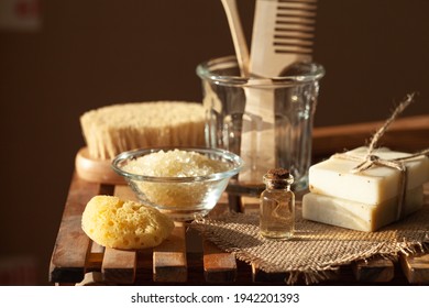 Zero waste and sustainable lifestyle concept. Eco-friendly bathroom accessories. Handmade soap, organic essential oil, sea salt, wooden background. Home body and face care. Contrast light, close-up