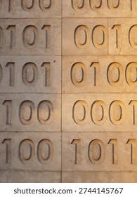 Zeros and ones of binary code are carved as a relief pattern int