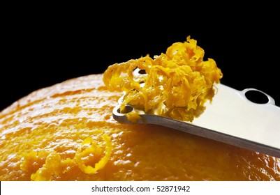 Zesting An Orange.  Close-up Of Zester, With Black Background.