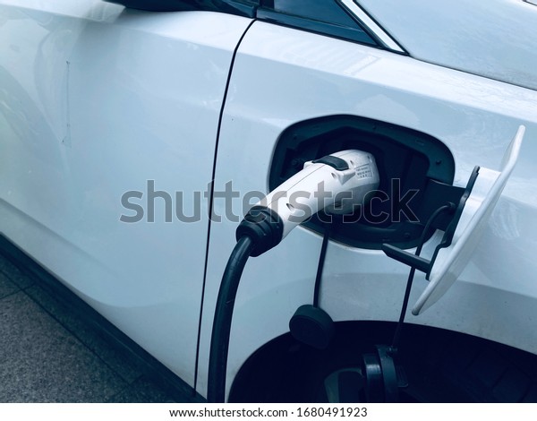 Zhenjiang,\
Jiangsu Province, China - March 19,2020 : Power supply connect to\
electric vehicle for charge the battery. Car and the charge station\
designed for EV CARD Rental Car in China.\
