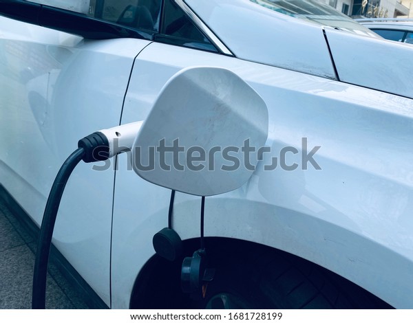 Zhenjiang,\
Jiangsu Province, China - March 19,2020 : Power supply connect to\
electric vehicle for charge the battery. Car and the charge station\
designed for EV CARD Rental Car in China.\

