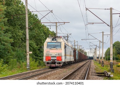 Zhmerynka, Ukraine - Autumn 2021: A locomotive with a long train loaded with grain enters the seaport. Railway freight transportation. Ukrainian railway