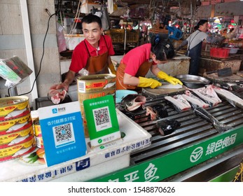 Zhongshan,China-November 3, 2019:fish retailer in Chinese market with Wechat and Alipay QR codes payment in front.