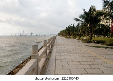 Zhuhai, China - April 2015 : Spacious Seaside Park And Pedestrian With Nice Background View Of Modern Bridge Over The Sea. 