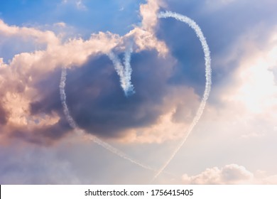 Zhukovskiy, Russia - September 1, 2019. A group of professional pilots of military aircraft shows tricks in the sky, leaving beautiful traces of clouds in the shape of a heart. Love is in the air.