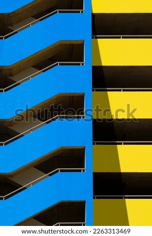 Zig Zag Staircase outside of blue and yellow parking garage building in vertical frame