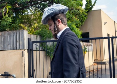 Zikhron Ya'akov, Israel - 11 19 2021: Haredi Orthodox Jew With Plastic Bag On His Head Against Rain.