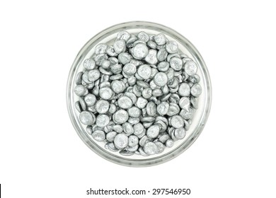 Zinc granules in a glass dish on a white background