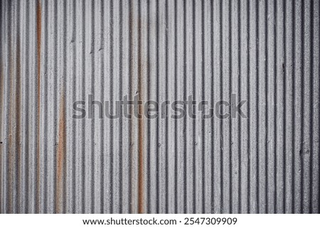 Zinc texture. Closed up details of silver zinc plate with small wavy pattern texture and background. Small tear rusty corrugated metal wall texture