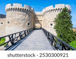 Zindan Gate stands as a prominent entryway to the historic Belgrade Fortress. Visitors can appreciate its medieval architecture against a clear blue sky, creating a scenic view.