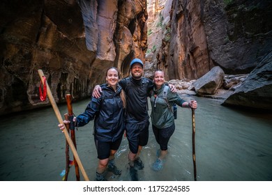 ZION NATIONAL PARK, UTAH/USA 6/13/18: Three Backpacking Friends With Hiking Poles Wading Through The Virgin River Of The Narrows.