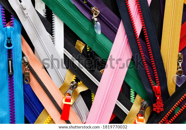 Zip background texture of zippers\
sliders. a lot of zippers in different colors. sewing clothes,\
atelier, fabric and accessories shop. hobby diy\
concept