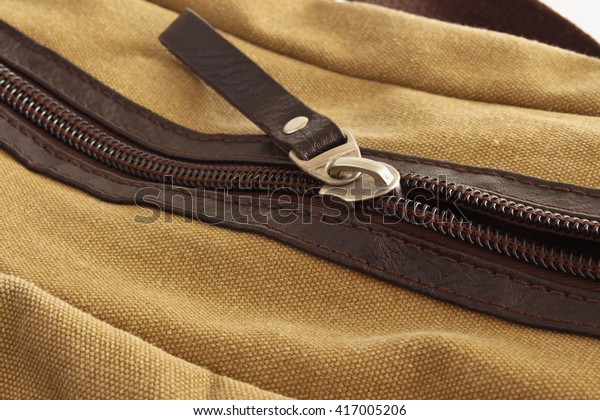 Zip closure on\
the brown bag on her\
pockets