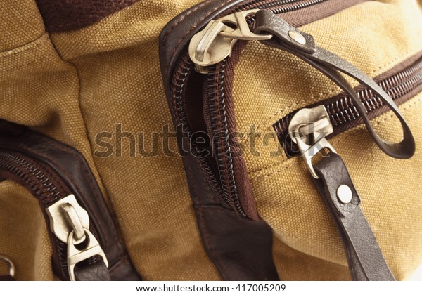 Zip closure on\
the brown bag on her\
pockets