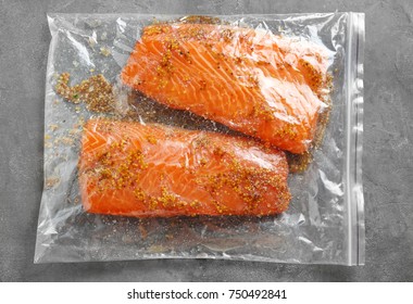 Zip Lock Bag With Salmon Fillet In Honey Mustard Marinade On Table