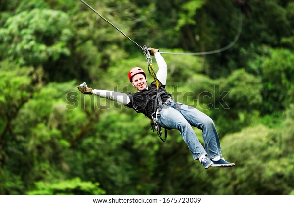 zipline canopy zip line wire adventure jungle forest\
sport flight mature masculine pilgrim wearing informal linen on\
zipline or canopi experience in ecuadorian rain forest zipline\
canopy zip line wire