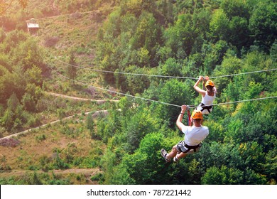 Zipline is an exciting adventure activity. Man and woman hanging on a rope-way. Tourists ride on the Zipline through the canyon of the Tara River Montenegro. Couple in helmets is riding on a cable car - Powered by Shutterstock