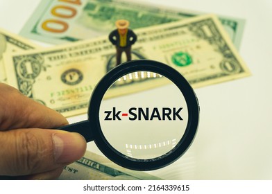 zk-SNARK.Magnifying glass showing the words.Background of banknotes and coins.basic concepts of finance.Business theme.Financial terms.
