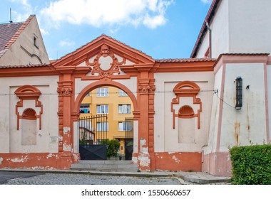 Zlutice, Czech republic - June 04 2011: Entrance gate from 1680, one of the last remains of former chateau Zlutice. A modern prefab house can be seen beyond the entrance. - Shutterstock ID 1550660657