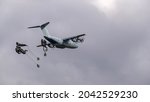 ZM401 RAF Royal Air Force Airbus C.1 A400M Atlas military cargo plane on a low-level cargo parachute drop exercise, grey sky light cloud