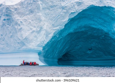 Zodiac In Front Of Enormous Ice Berg In Antarctica