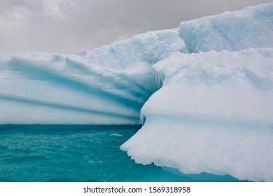 Zodiac rafting through icebergs in crystal blue waters, Antarctica coastline