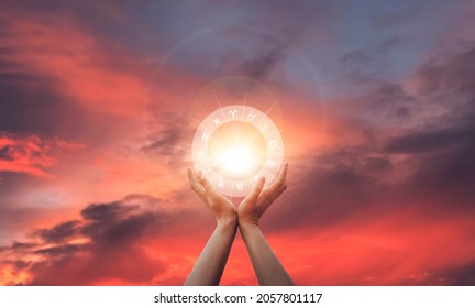 Zodiac signs inside of horoscope circle in woman hand at sunset. Astrology and horoscopes.