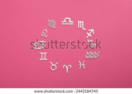 Zodiac signs on pink background, flat lay. Space for text
