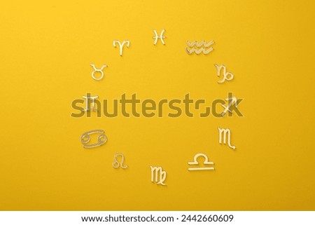 Zodiac signs on yellow background, flat lay. Space for text