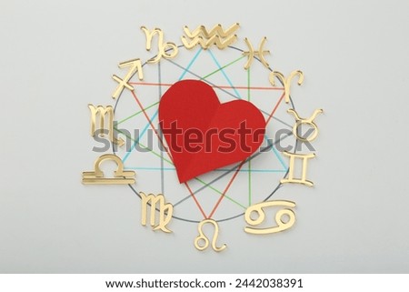 Zodiac wheel with red heart on light grey background, flat lay