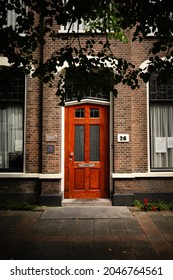 ZOETERMEER, NETHERLANDS - Aug 20, 2021: A vertical shot of a brick building with a wooden door on Dorpstraat Street in Zoetermeer, Netherlands