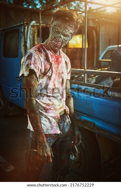 Zombie apocalypse. Angry bloody zombie man\
in destroyed city. Halloween. Horror movie.\
