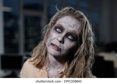 Zombie female standing in front of camera in dark room or office