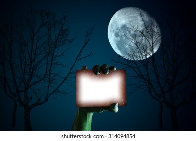 Zombie Hand Holding A Blank Sign Card Halloween Night Sky