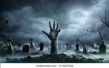 Zombie Hand Rising Out Of A Graveyard In Spooky Night
				